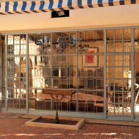 Antique steel windows and doors, exterior view looking through a wall of glass windows.