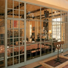 Antique steel windows and doors, exterior view looking through a wall of glass windows.