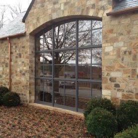 Hopes custom arched steel windows on a stone bank building help let in natural light, exterior view, Iberia Bank.