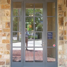 Stone bank building with Hopes steel and glass doors, bank entrance door with sidelights, Iberia-Bank.