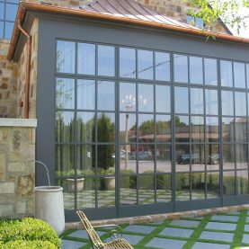 Conference room space surrounded by wall of full-height Hopes steel windows on a stone bank building, close up side view, Iberia-Bank.