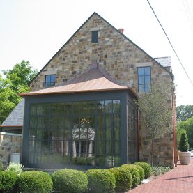 Conference room space surrounded by walls of Hopes steel windows on a stone bank building, side view, Iberia-Bank.