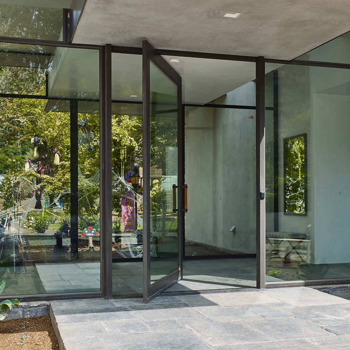 Hopes Windows Jamestown175 Series steel pivot doors displayed in a modern entry way.